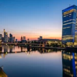 صورة واقعية لمبنى البنك المركزي الأوروبي في فرانكفورت عند الغسق مع انعكاس الإضاءة على نهر الماين في ظل قرارات أسعار الفائدة أبريل 2026