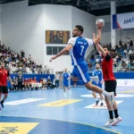 لاعب كرة يد يقفز عالياً لتسديد الكرة في مباراة احترافية تمثل نادي النواعير السوري.