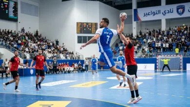 لاعب كرة يد يقفز عالياً لتسديد الكرة في مباراة احترافية تمثل نادي النواعير السوري.