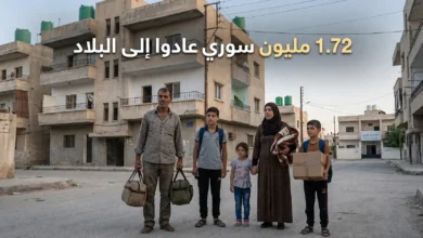 عائلة سورية عائدة إلى البلاد تقف في حي سكني تمت إعادة تأهيله جزئياً مع ظهور عنوان 1.72 مليون سوري عادوا إلى البلاد