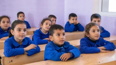 تلاميذ بالزي الأزرق الموحد يجلسون على المقاعد الخشبية مع انطلاق عودة الطلاب إلى المدارس.