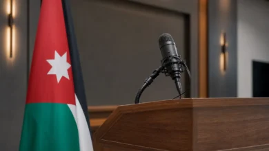 ميكروفون صحفي بجانب العلم الأردني في قاعة إيجاز صحفي رسمي