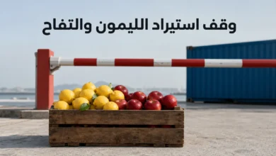 صندوق خشبي يضم ليموناً وتفاحاً أمام حاجز جمركي مغلق يعبّر عن قرار وقف استيراد الليمون والتفاح